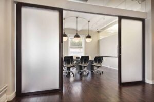 Board room with translucent sliding door system from Raydoor partitioning the space and natural light coming through windows