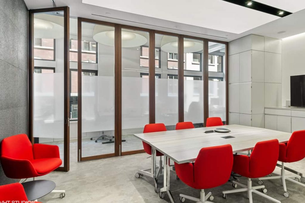 A single panel of this partially frosted wall opens into a contemporary conference room.