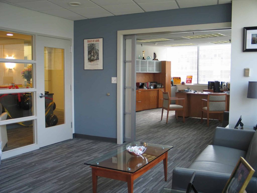 A wide-opening sliding door system makes an intimate office space more flexible and connected to the rest of the room