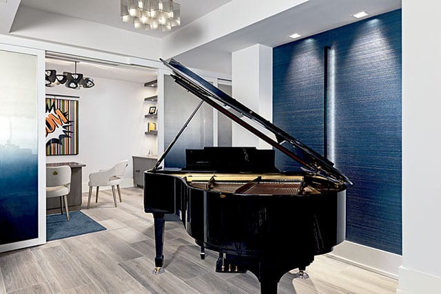 A large black grand piano set in front of opened white opaque Raydoor doors.