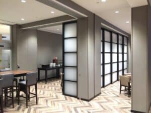Lobby area in hotel with acrylic glazing inserts in Raydoor solution partitioning food area