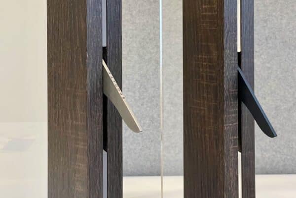 Raydoor's sleek, integrated metal pull handles in silver and black, flush-mounted in dark wood frames for contemporary sliding walls and doors.