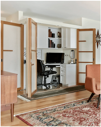A set of French doors swings open to reveal a cozy home office.