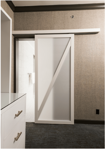 A single-panel barn door provides a simple, comforting look. The translucent panel balances privacy and light between a bedroom and bathroom.