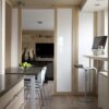 Minimalist kitchen design with frosted glass sliding doors, offering a clean and airy space with seamless functionality.
