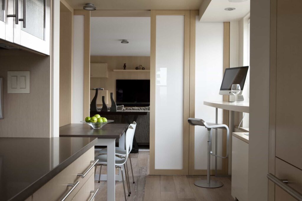 Minimalist kitchen design with frosted glass sliding doors, offering a clean and airy space with seamless functionality.